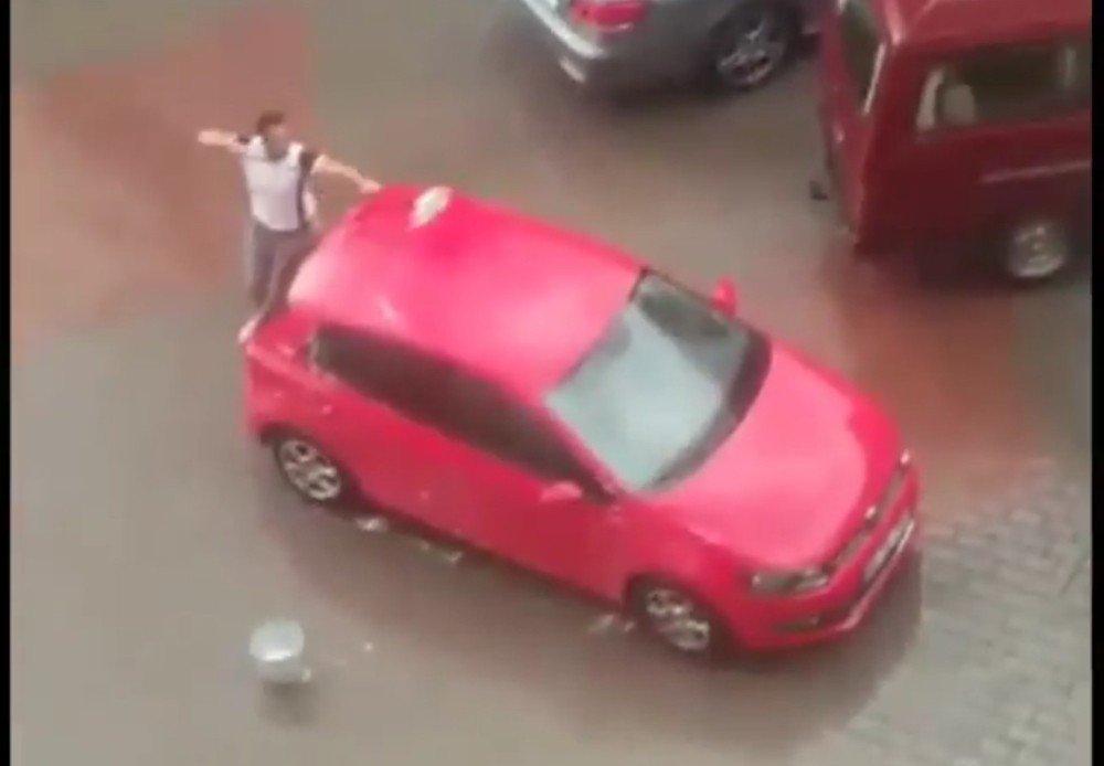 Başkent’te sağanak yağış altında şortla arabasını yıkadı