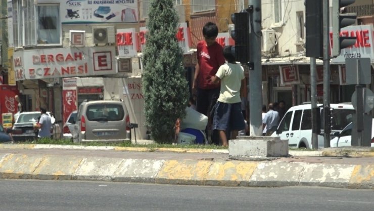 Çocuklar araçların arasına dalıp su satmaya çalışıyor